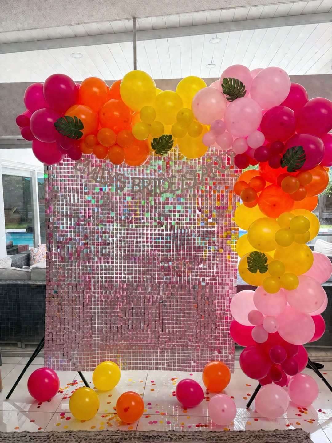 Bedroom styled with a giant BRIDE foil balloon banner over the bed and cascading pink, orange, yellow and magenta balloons