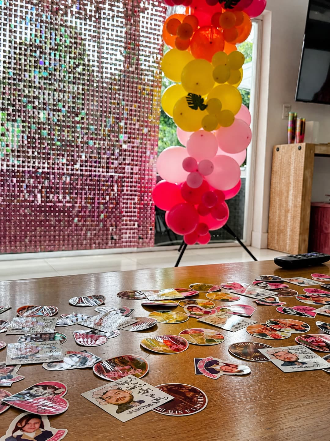 Pink shimmer photo backdrop framed by a lush balloon garland, staged in front of the pool for photos