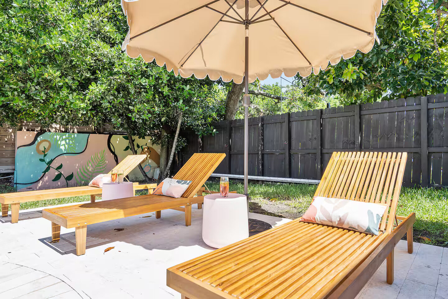 Outdoor lounge area with wicker seating and a colorful mural at a Platinum Retreats property