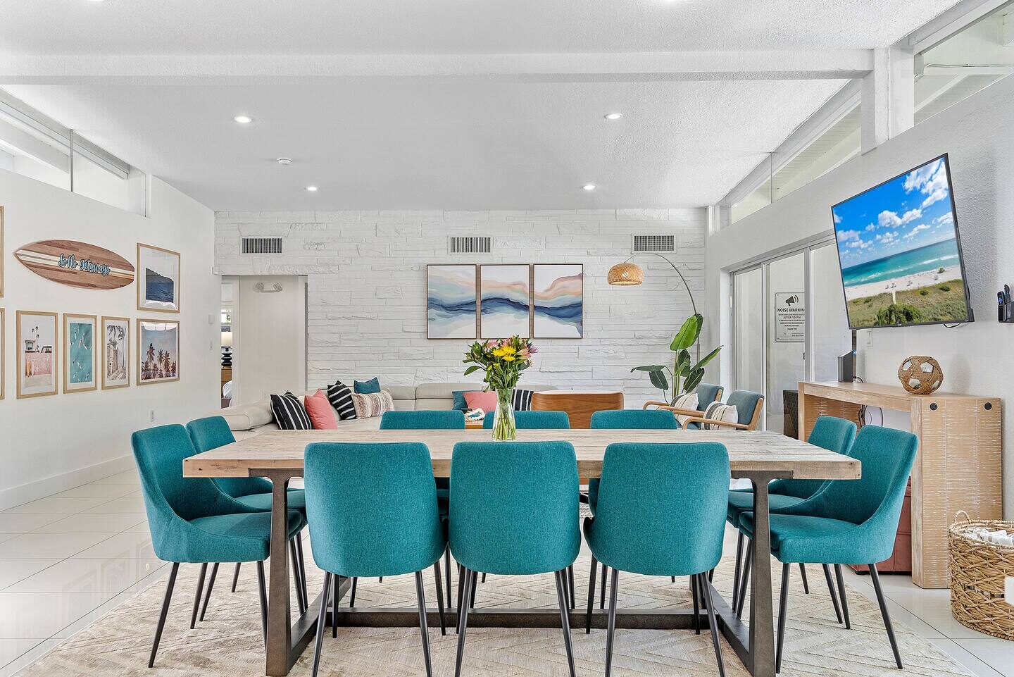 Modern dining area with teal chairs and stone accent wall