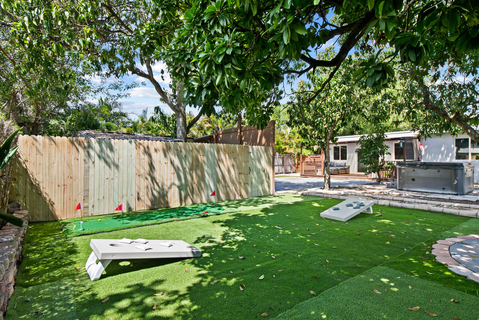 Artificial turf backyard with putting green and cornhole