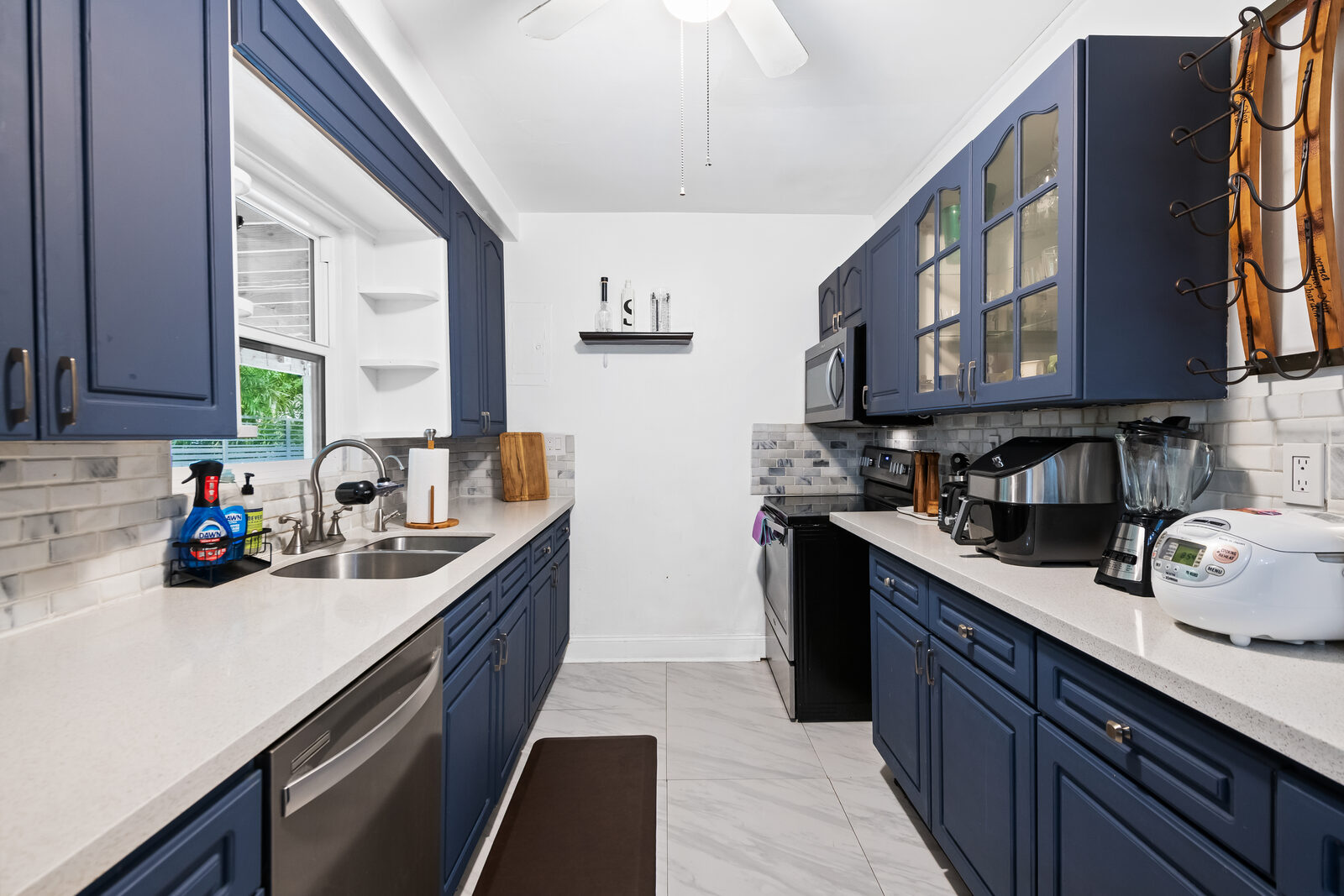 Galley kitchen with navy blue cabinets and white countertops